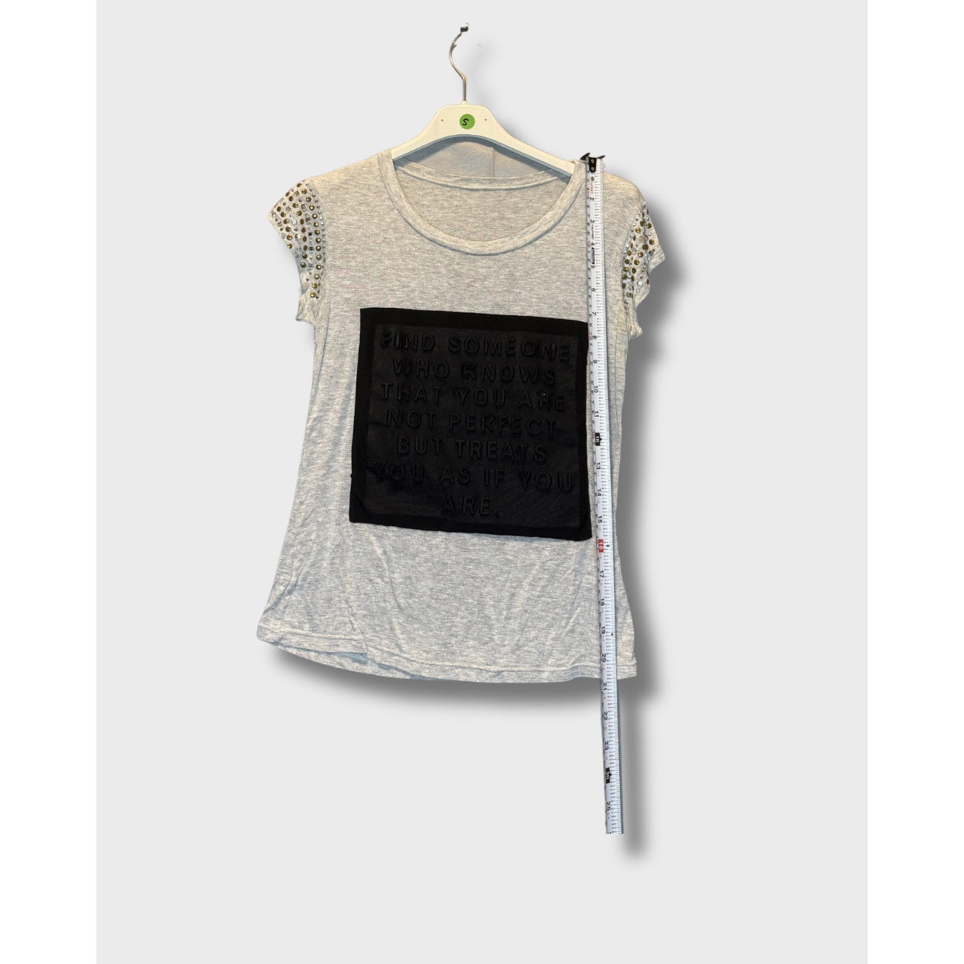 Blusa gris con mensaje escrito y decorado en los hombros