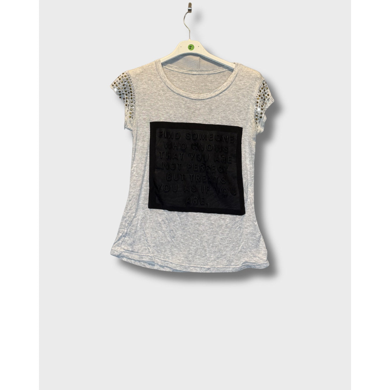 Blusa gris con mensaje escrito y decorado en los hombros