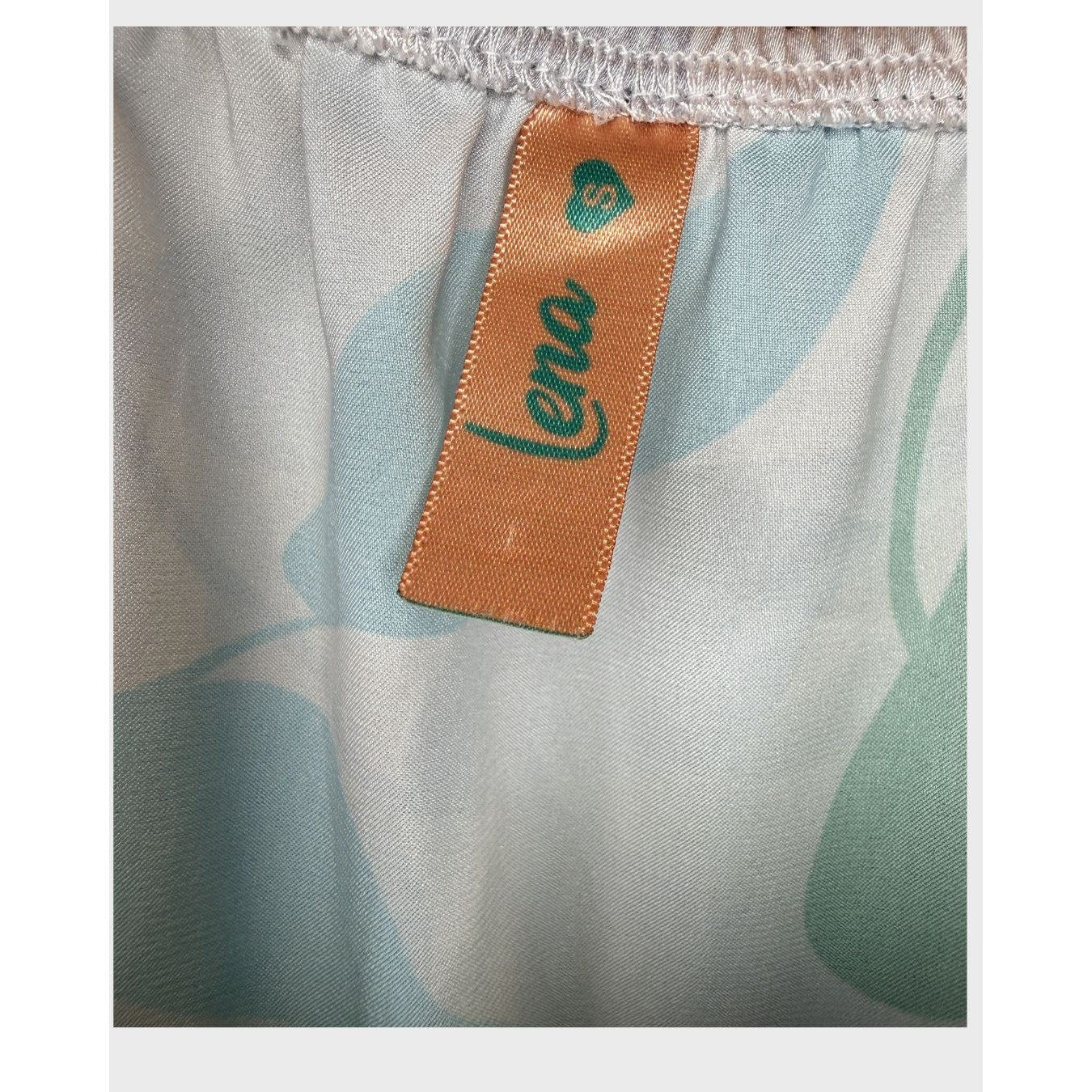 Blusa campesina con estampado floral vibrante sobre fondo claro. Talla S