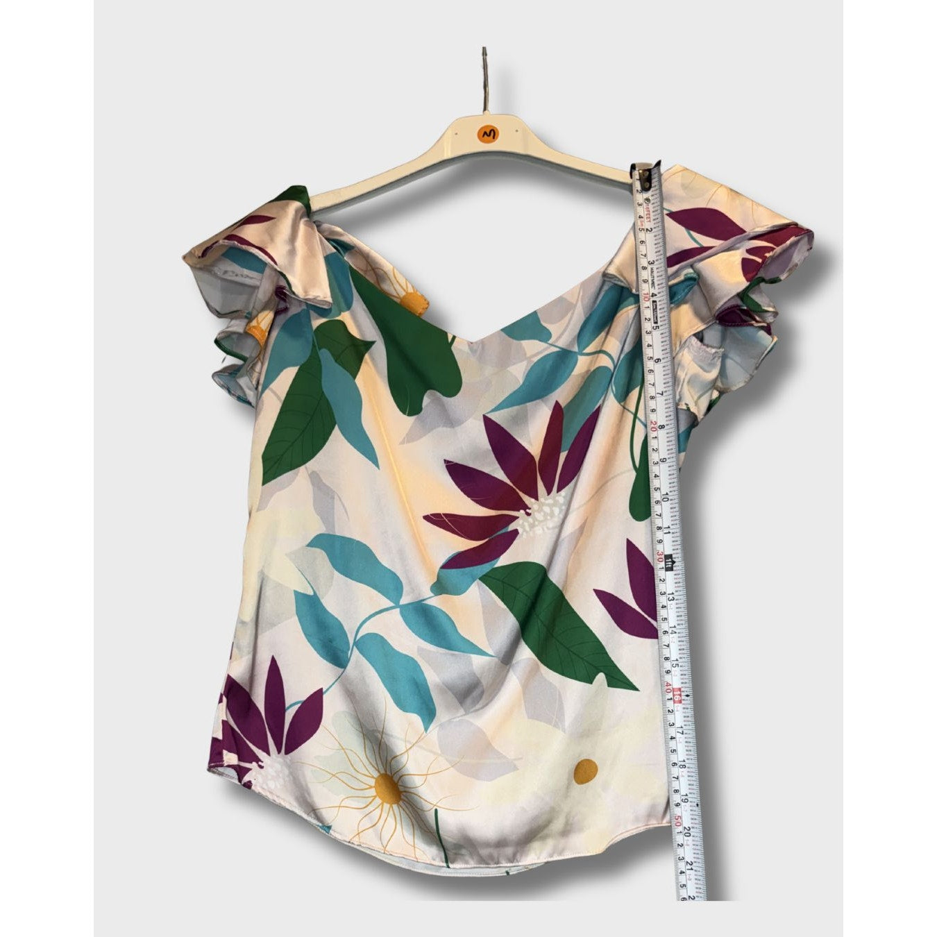 Blusa campesina con estampado floral vibrante sobre fondo claro. Talla S
