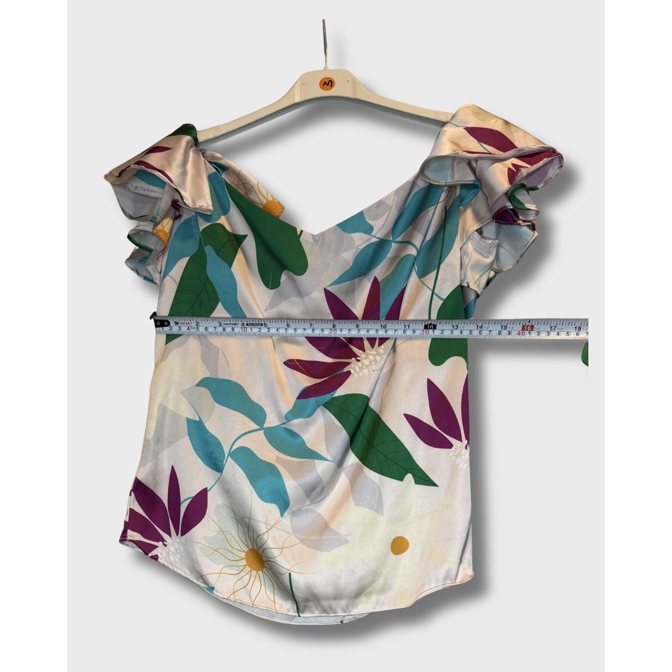 Blusa campesina con estampado floral vibrante sobre fondo claro. Talla S