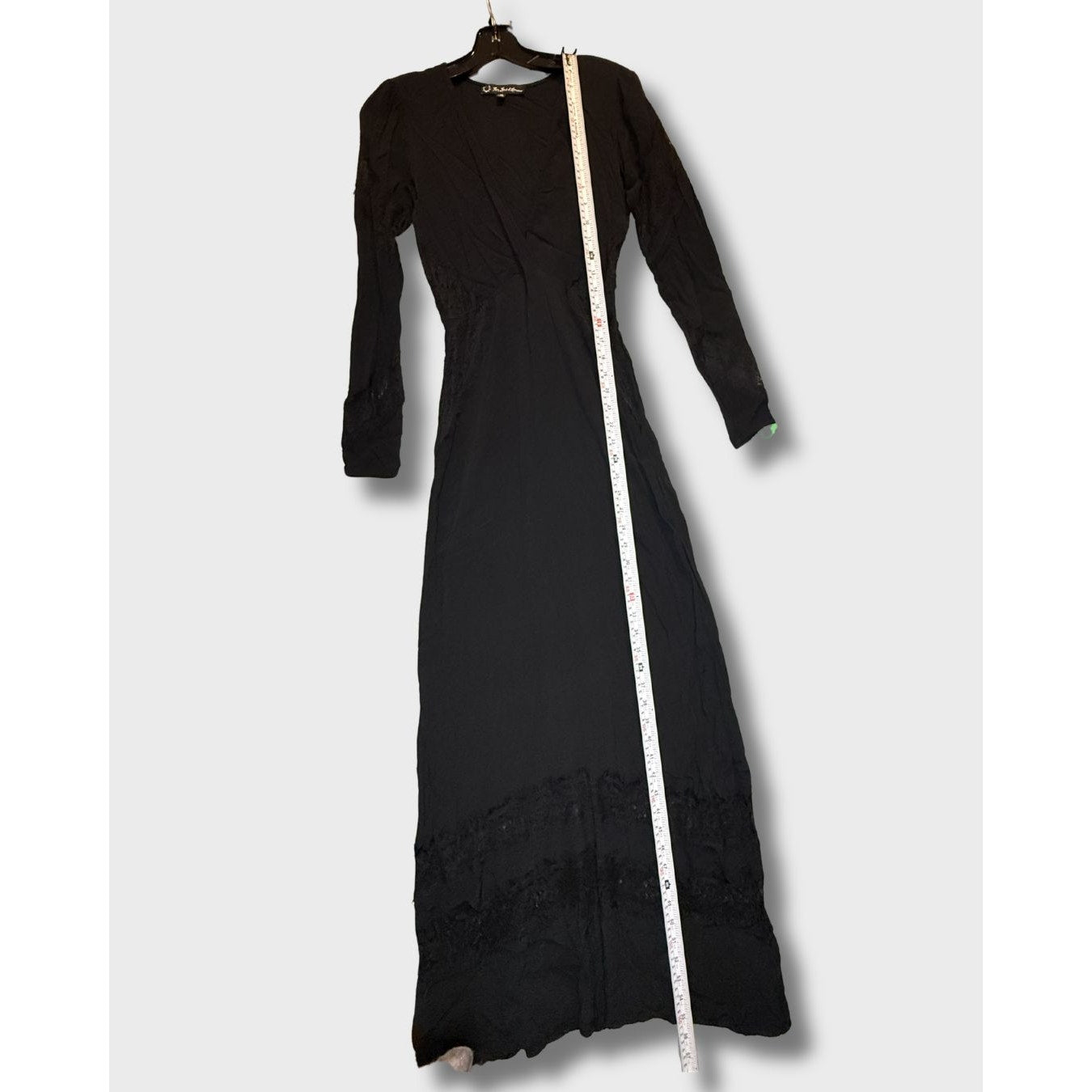 Vestido largo negro de manga larga con detalles de encaje en el bajo. Talla S.