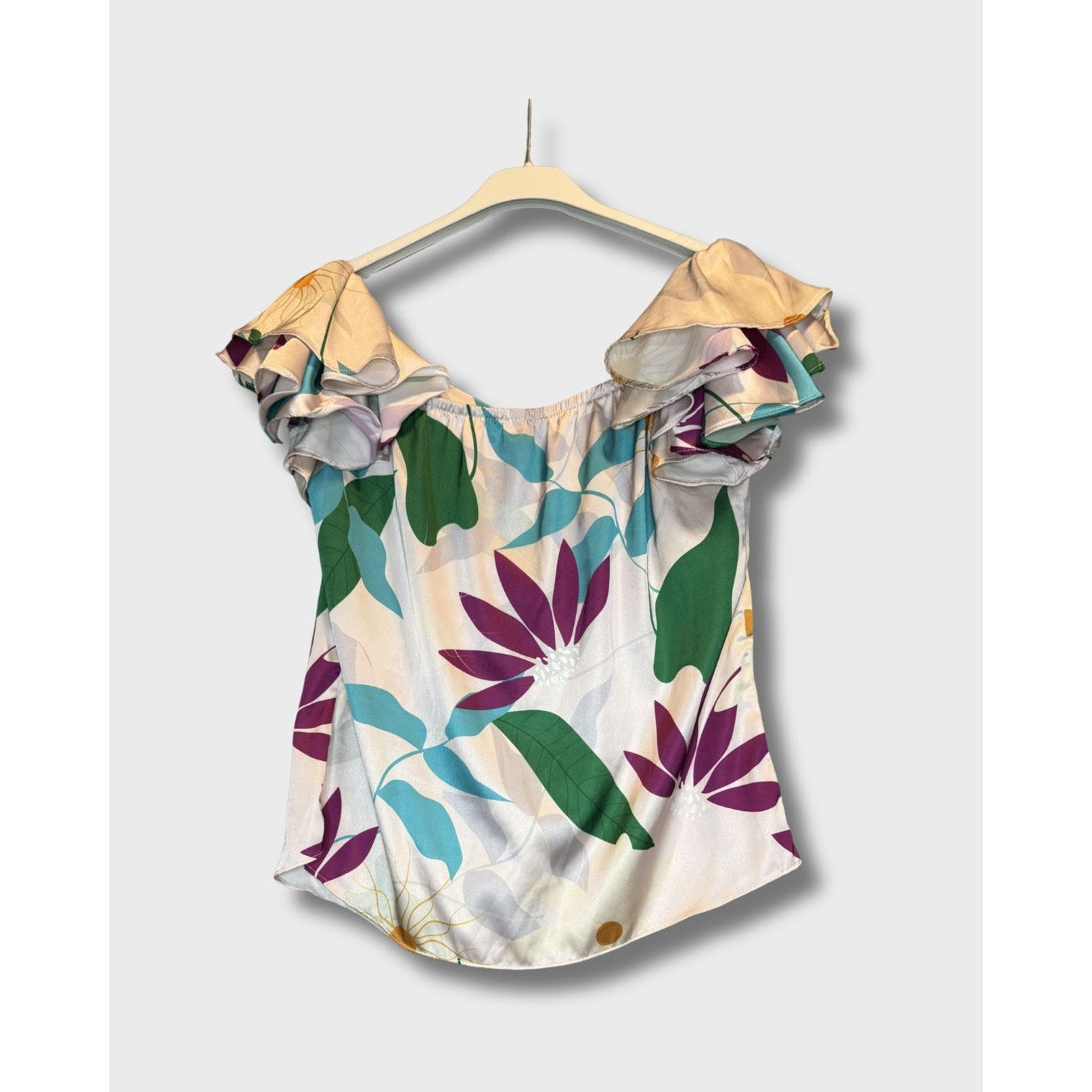 Blusa campesina con estampado floral vibrante sobre fondo claro. Talla S
