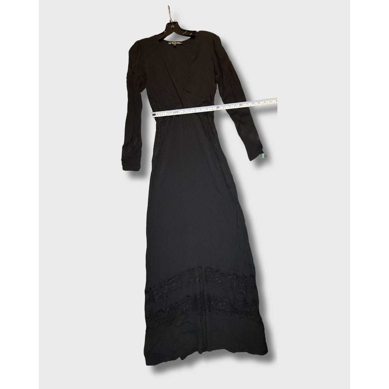 Vestido largo negro de manga larga con detalles de encaje en el bajo. Talla S.