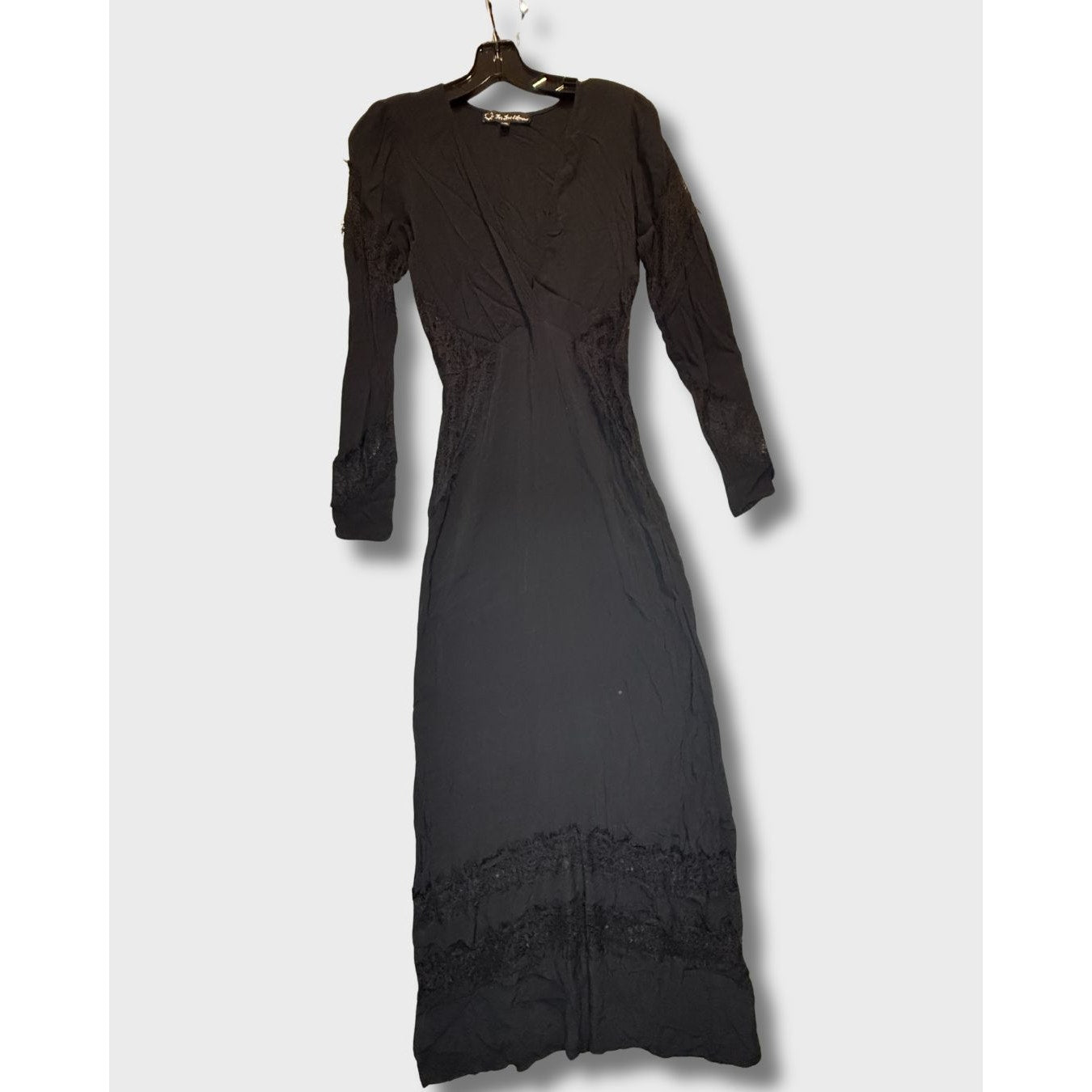 Vestido largo negro de manga larga con detalles de encaje en el bajo. Talla S.