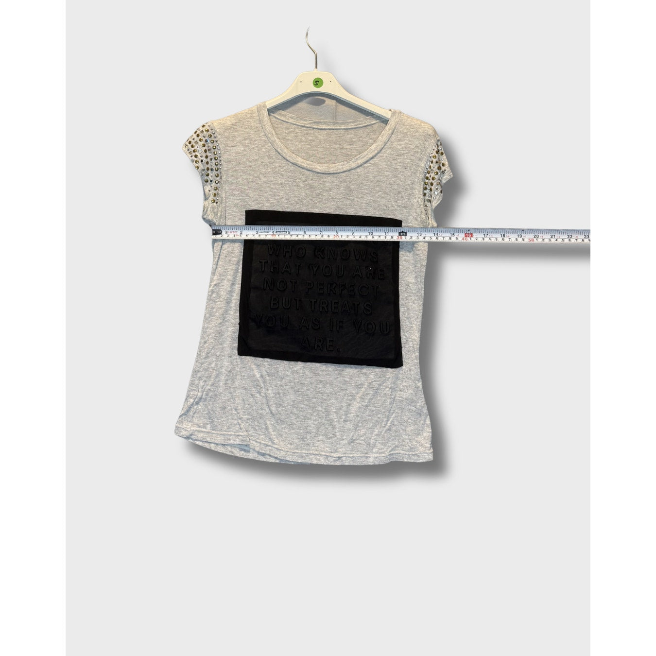 Blusa gris con mensaje escrito y decorado en los hombros