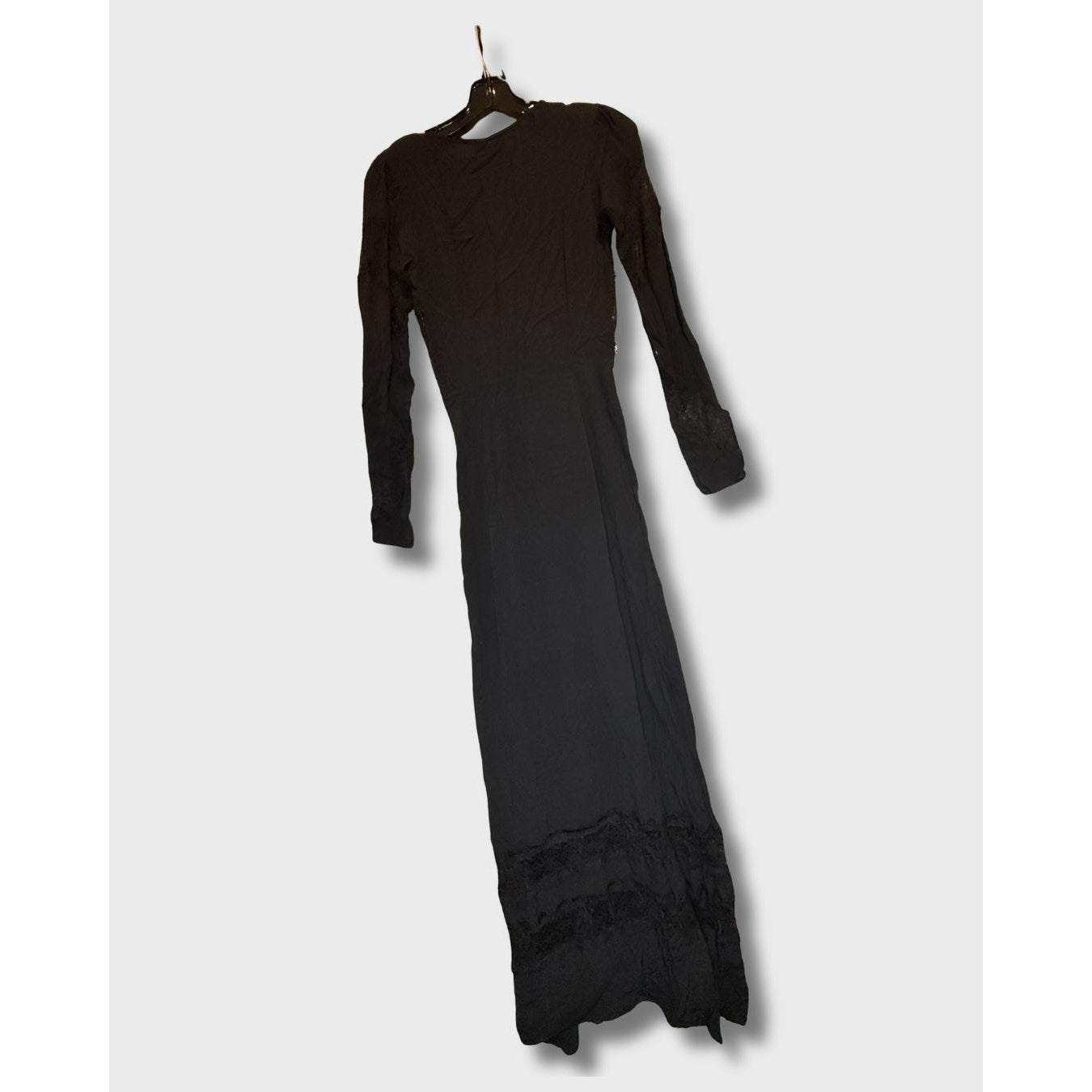 Vestido largo negro de manga larga con detalles de encaje en el bajo. Talla S.