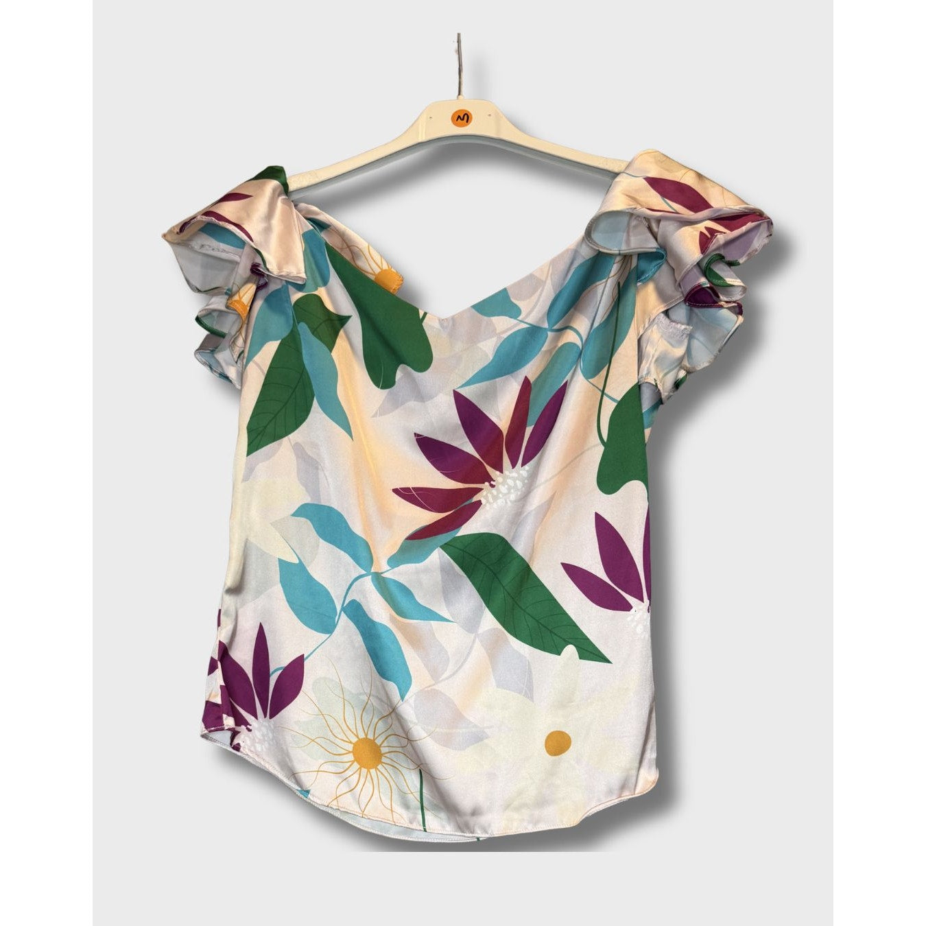 Blusa campesina con estampado floral vibrante sobre fondo claro. Talla S